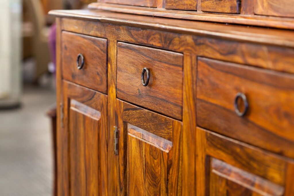 A dresser with three drawers and cabinets.